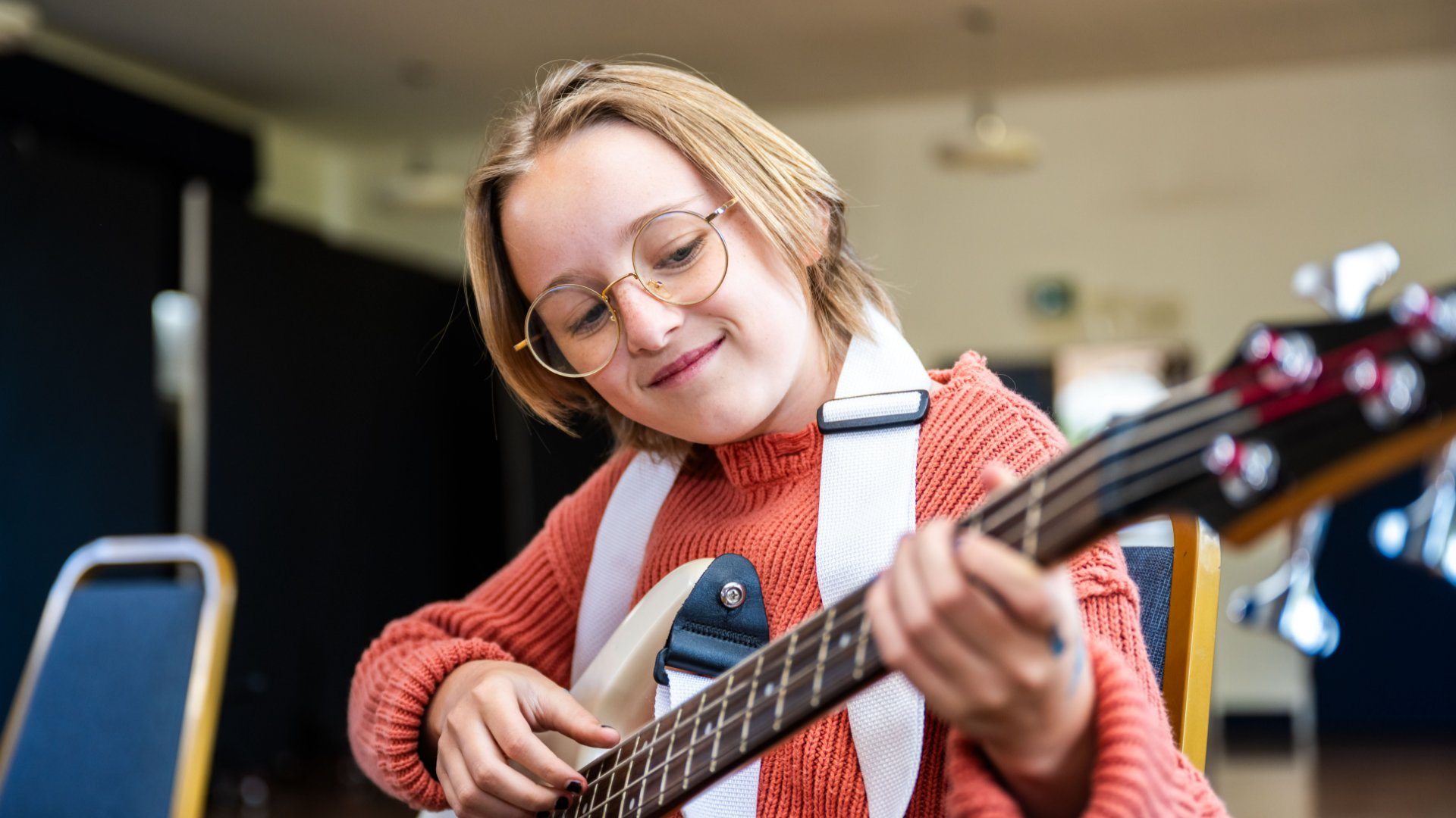 Middle school student playing guitar in music class at Riviera Ridge School.